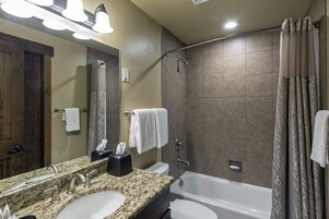 Un baño con dos lavabos, un espejo, ducha y bañera.
