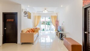 A modern hotel lobby with a sofa, a bench, a small table, and a door with a welcome sign. - Timeless Pool Villa Huahin (Hua Hin)