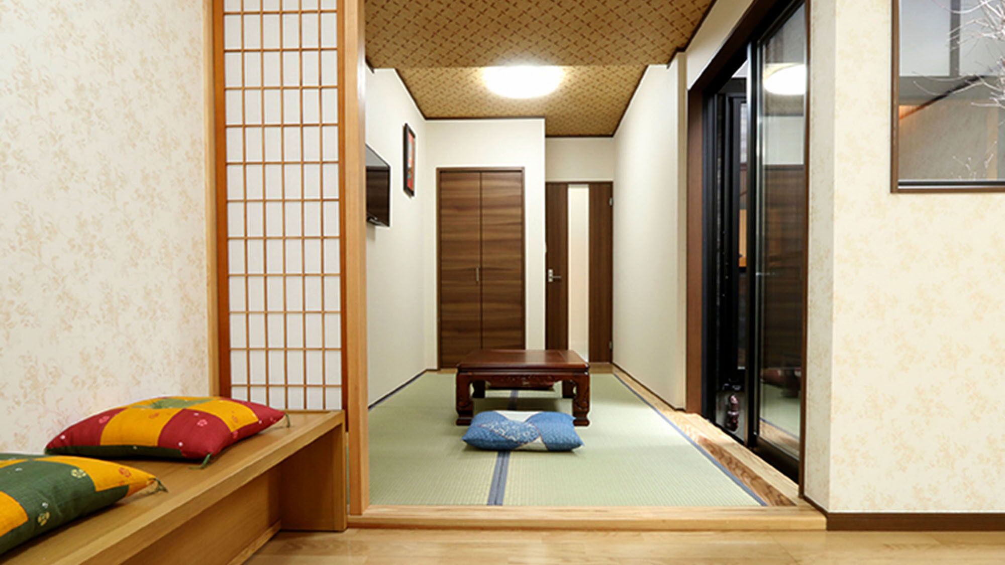 Una habitación japonesa tradicional con suelo de tatami, una mesa de madera baja y una puerta corredera.