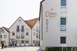 An Othello apartment hotel with a traditional European architectural style, featuring a symmetrical facade, multiple windows, and a central entrance.