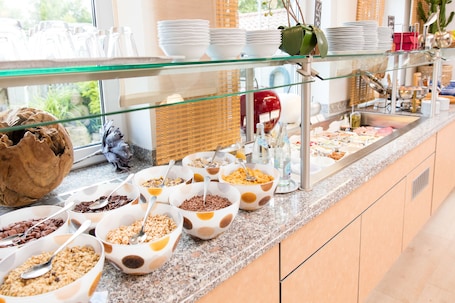 A buffet with various food items and utensils.