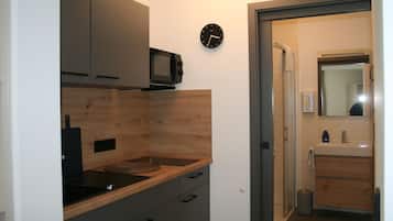 A modern kitchen with a microwave, wooden countertop, and cabinets.
