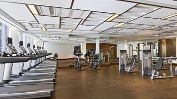 A gym with treadmills, weight machines, and mirrors.