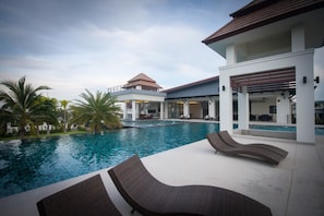 Um resort moderno com piscina, espreguiçadeiras e área externa coberta.