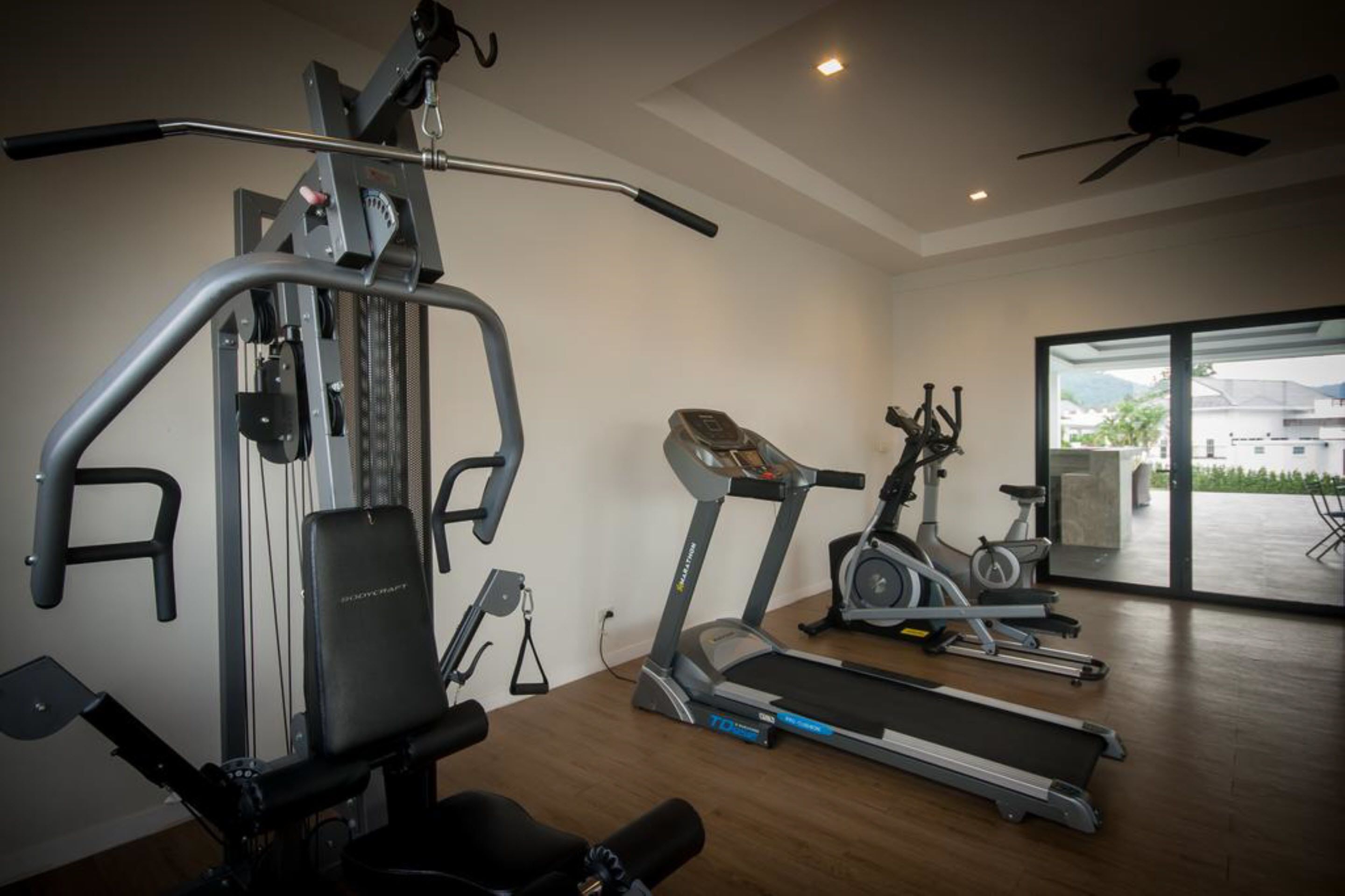 Ein Heimfitnessraum mit Laufband, Crosstrainer und Kraftmaschine.