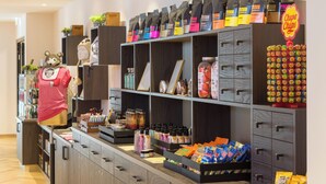 Un expositor de botiga amb diversos productes envasats, un maniquí i un rètol.