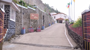 A street leading to a building with a stone wall and a sign reading "Irm Valley." - Jem Valley (Kodaikanal)