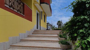 Un conjunt d'escales exteriors que condueixen a un edifici amb façana groga i una secció vermella.