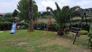 Un parc infantil amb tobogan, cadira d'oscalls i una panxa de vuita.
