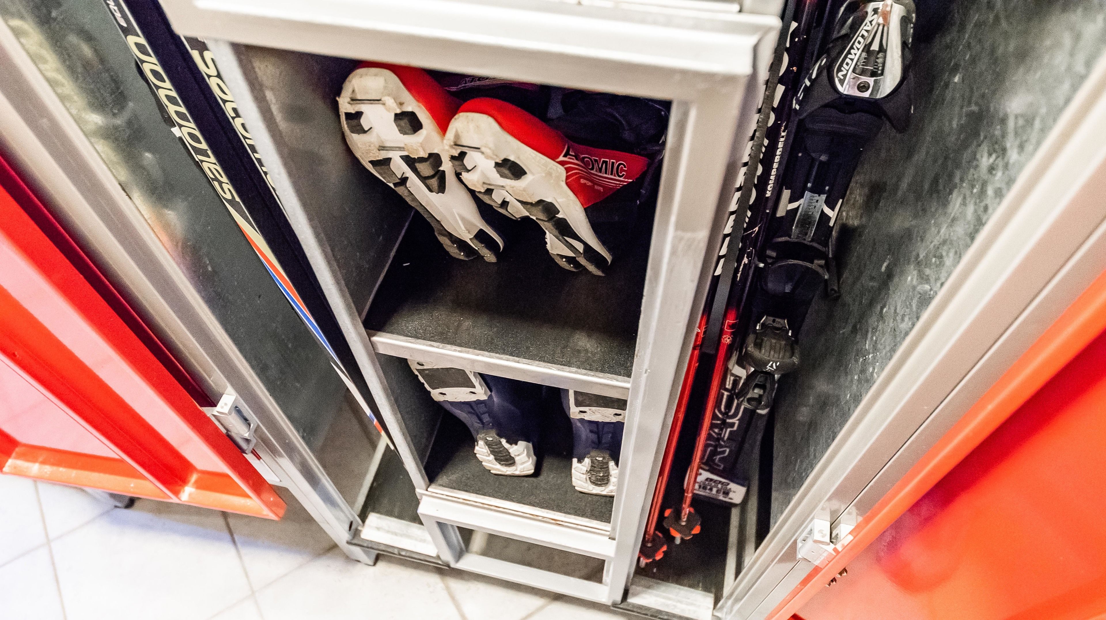 A storage unit with skis and ski boots.