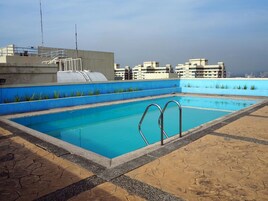 Una piscina al aire libre, sillones reclinables de piscina