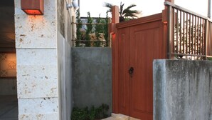 Una pared de concreto con una puerta de madera y un portón de metal.