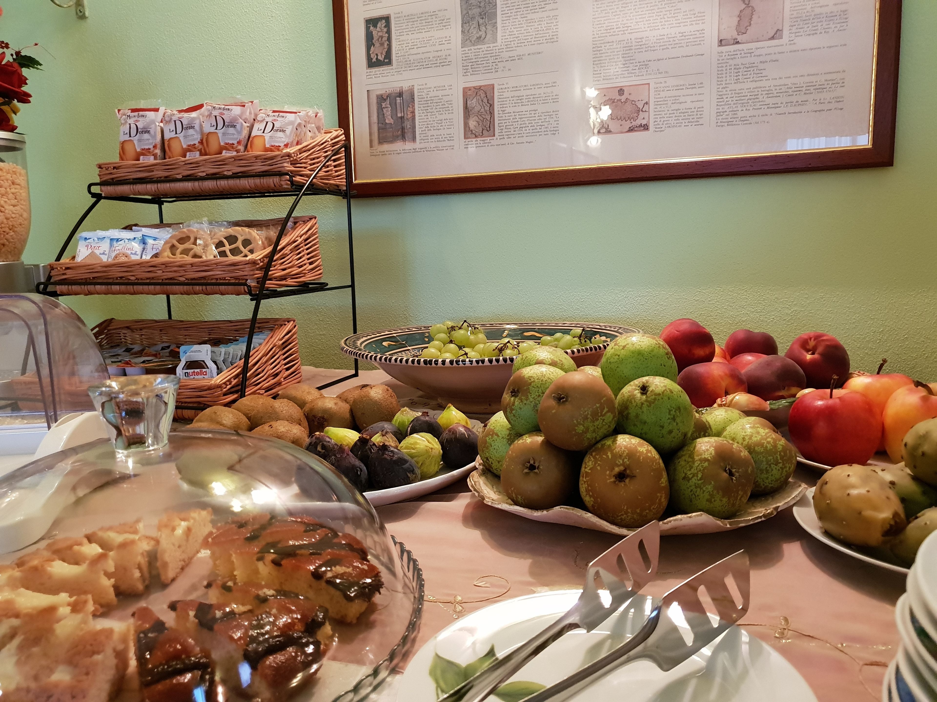 Una mesa de buffet con diversos alimentos, como frutas, pasteles y una selección de pan.