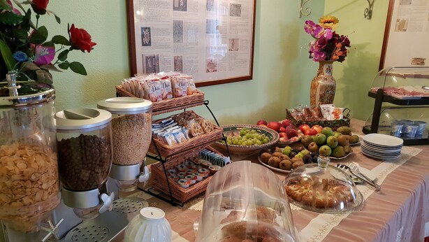 Ein reichhaltiges Buffet mit verschiedenen Speisen, darunter Obst, Gebäck und Beilagen.