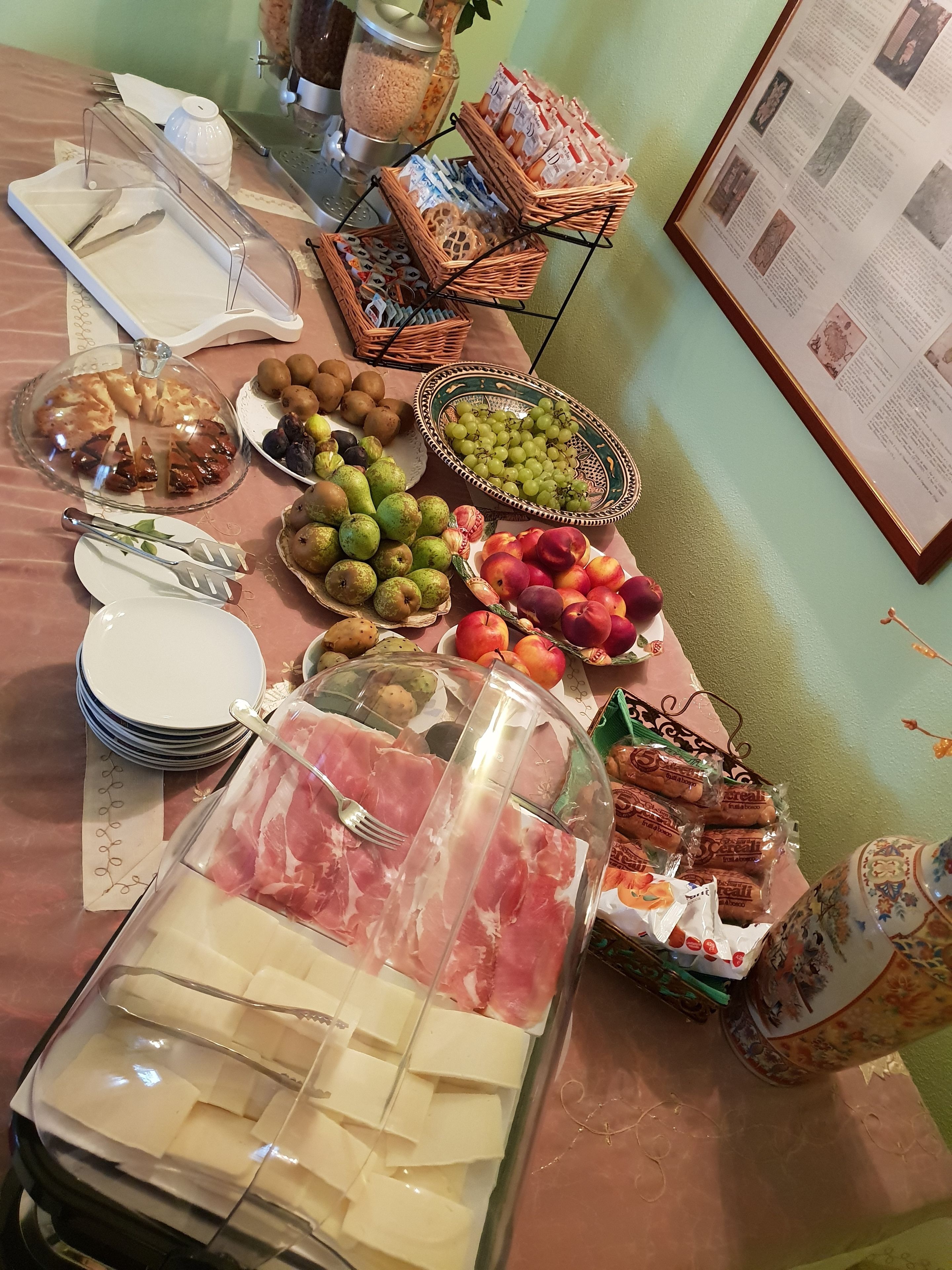 Una mesa de buffet con distintos alimentos, como frutas, quesos y carnes.