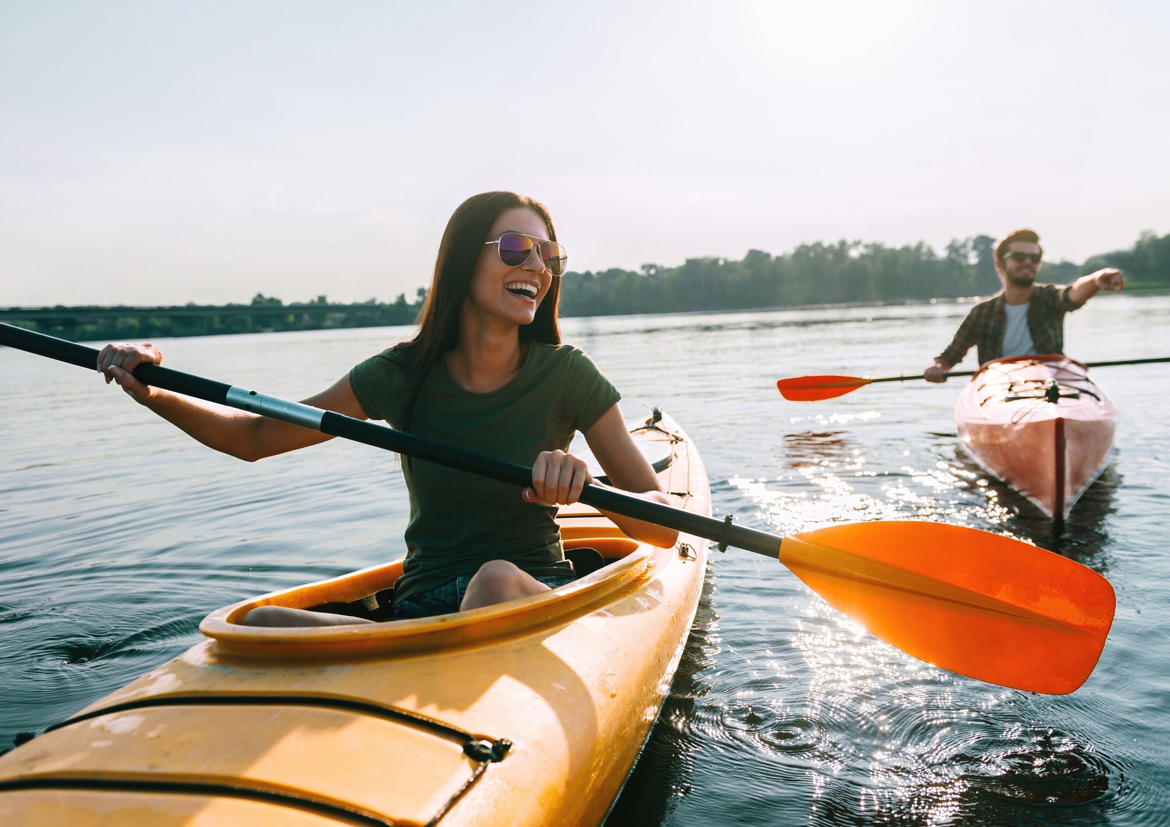 Two people kayaking on a calm body of water.