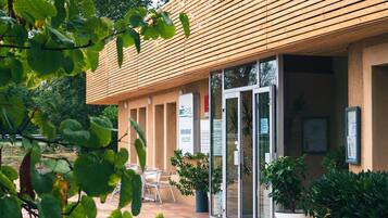 A modern building with a wooden slatted roof, a glass entrance, and a sign reading "BRIT HOTEL".