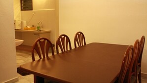 A dining area with a brown table and wooden chairs, a sink, and a mirror on the wall. - 32 First Island (George Town)