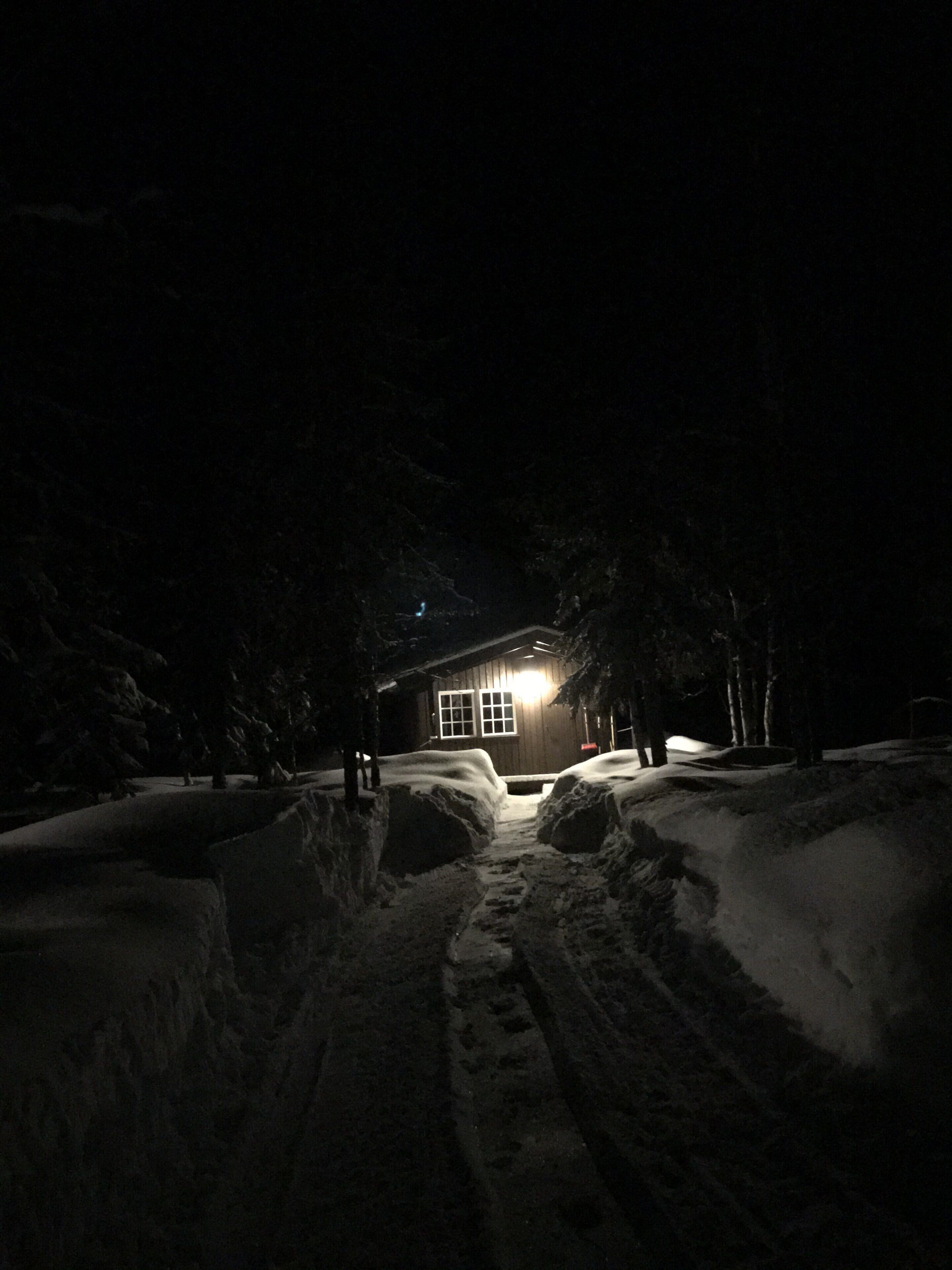 A cabin with a visible window and a light source outside.