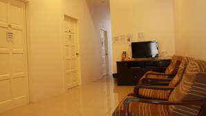 A hallway with a sofa and TV in a living area. - 34 First Island (George Town)
