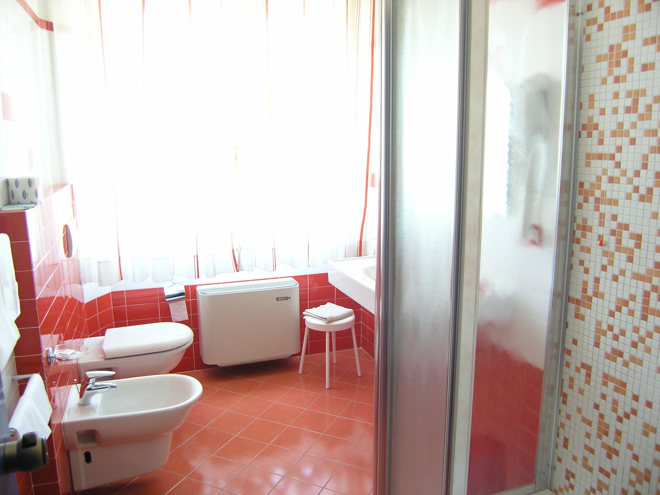 Une salle de bain équipée de toilettes, d’un bidet et d’un lavabo.