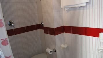 Un bagno con pareti a righe, un water, un porta asciugamani e uno spazio doccia.