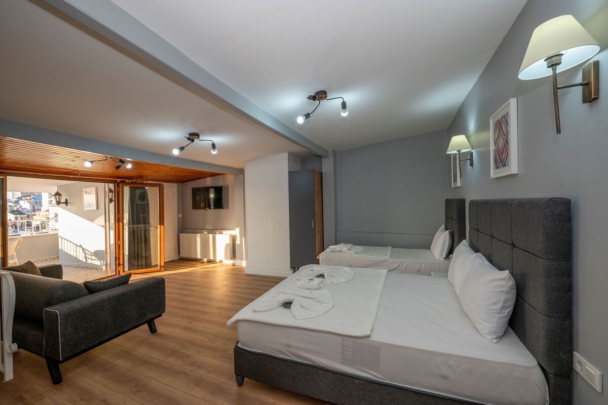Una habitación de hotel moderna con una cama grande, un sofá, un balcón y un televisor.