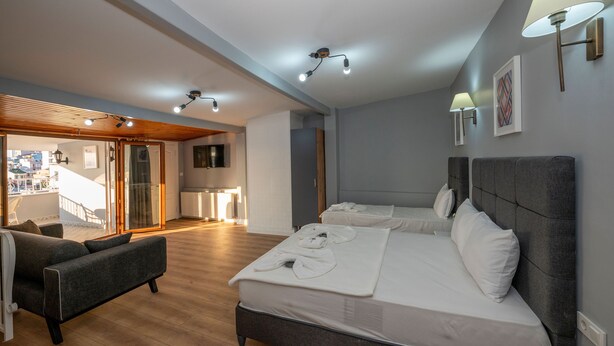 A hotel room with two beds, a sofa, and a balcony with a view. - Butterfly Suites (Istanbul)