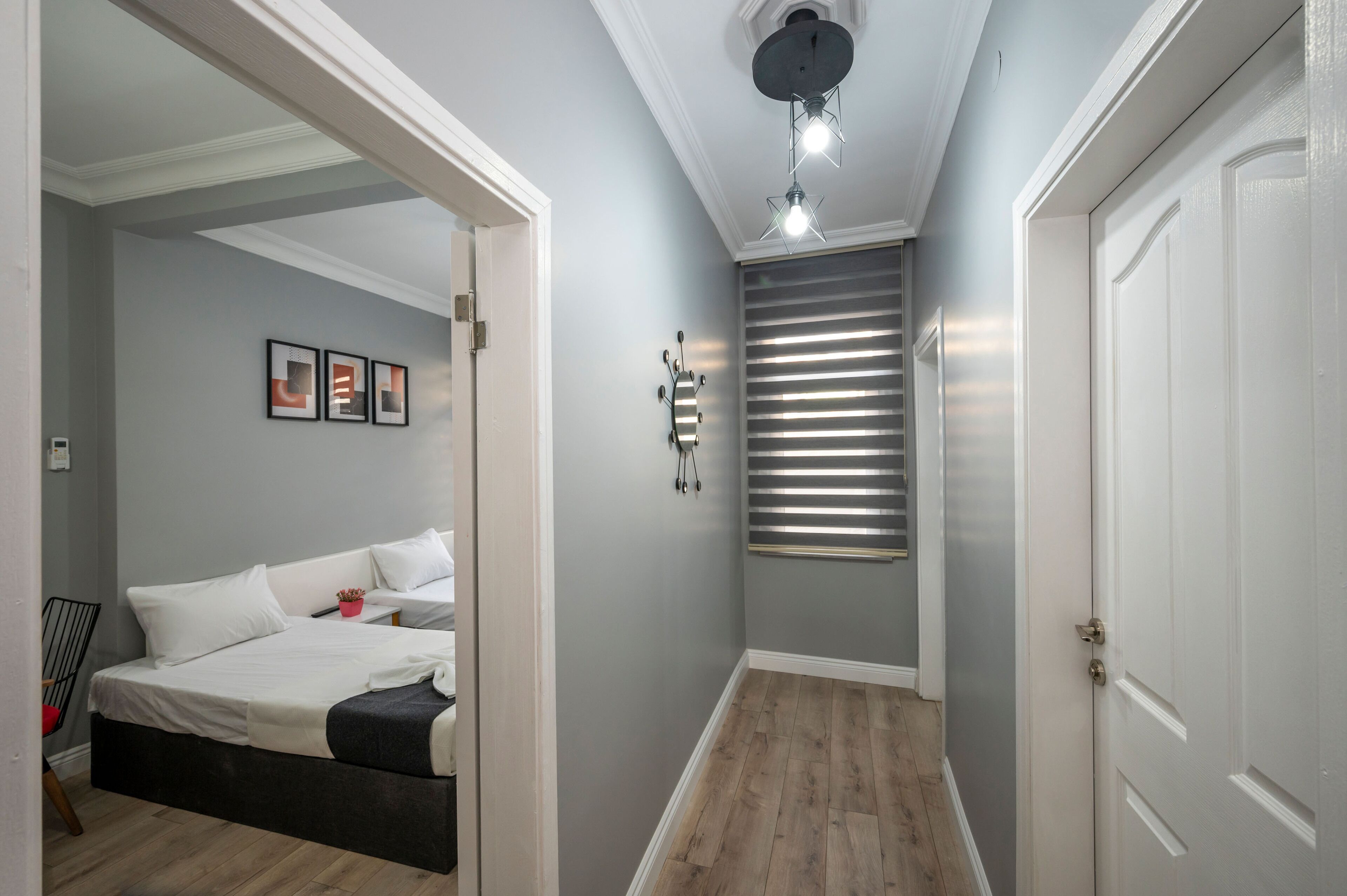 A bedroom with a bed, bedside table, and a wall-mounted mirror.