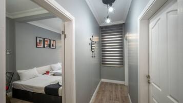 A bedroom with a bed, bedside table, and a wall-mounted mirror.
