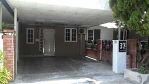 A building entrance with a gated driveway, a brick wall, and a sign with the number 37. - 37 First Island (George Town)