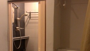 A bathroom with a shower, a towel rack, and a toilet. - 37 First Island (George Town)