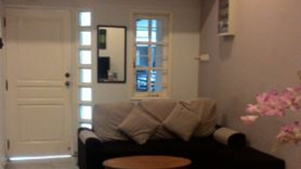 A living room with a sofa, a coffee table, a door, and a window. - 37 First Island (George Town)