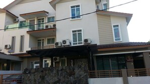 A multi-story residential building with balconies, air conditioning units, and a stone wall. - 67 First Island (George Town)