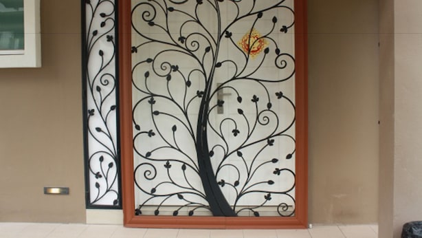 A decorative metal panel with a tree design, part of a building's exterior. - 67 First Island (George Town)
