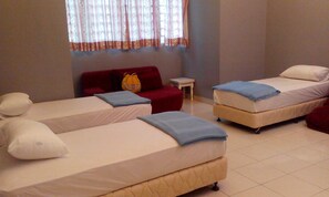 A hotel room with two single beds, a red sofa, a small table, and a window with curtains. - 67 First Island (George Town)
