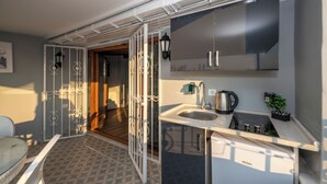 Una cocina compacta con lavamanos, estufa y armarios.