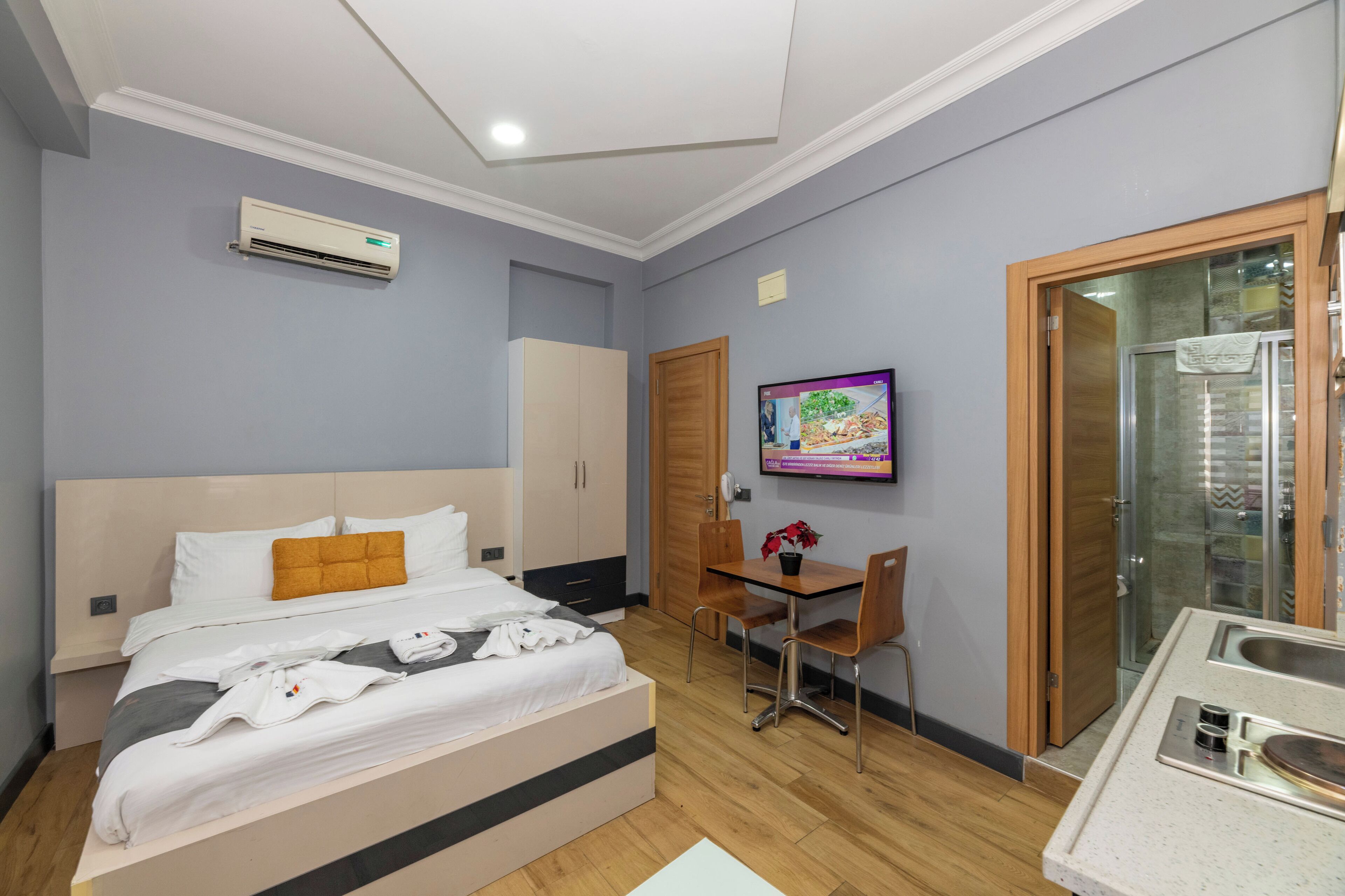 Une chambre d’hôtel équipée d’un lit, d’un bureau, d’une chaise, d’une télévision et d’un espace douche.