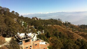 A mountainous landscape with a view of snow-capped peaks in the distance. - Mountain Resort (Baluwapati Deupur)