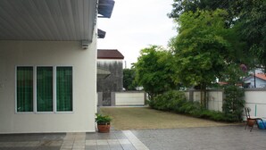 A residential area with a paved patio, a potted plant, and a chair. - 02 First Island (George Town)