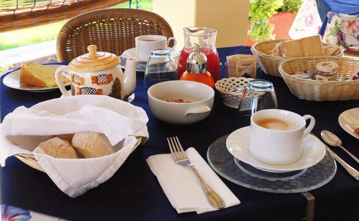 Een ontbijt met brood, koffie en thee op een tafel.
