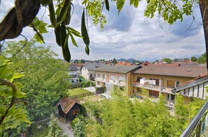 Ein Wohngebiet mit Häusern, einem kleinen Garten und einer Blick auf die entfernten Berge.