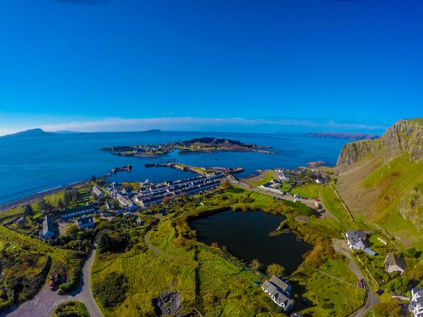 Vista aérea de un pueblo costero con un puerto, edificios y una extensa masa de agua.