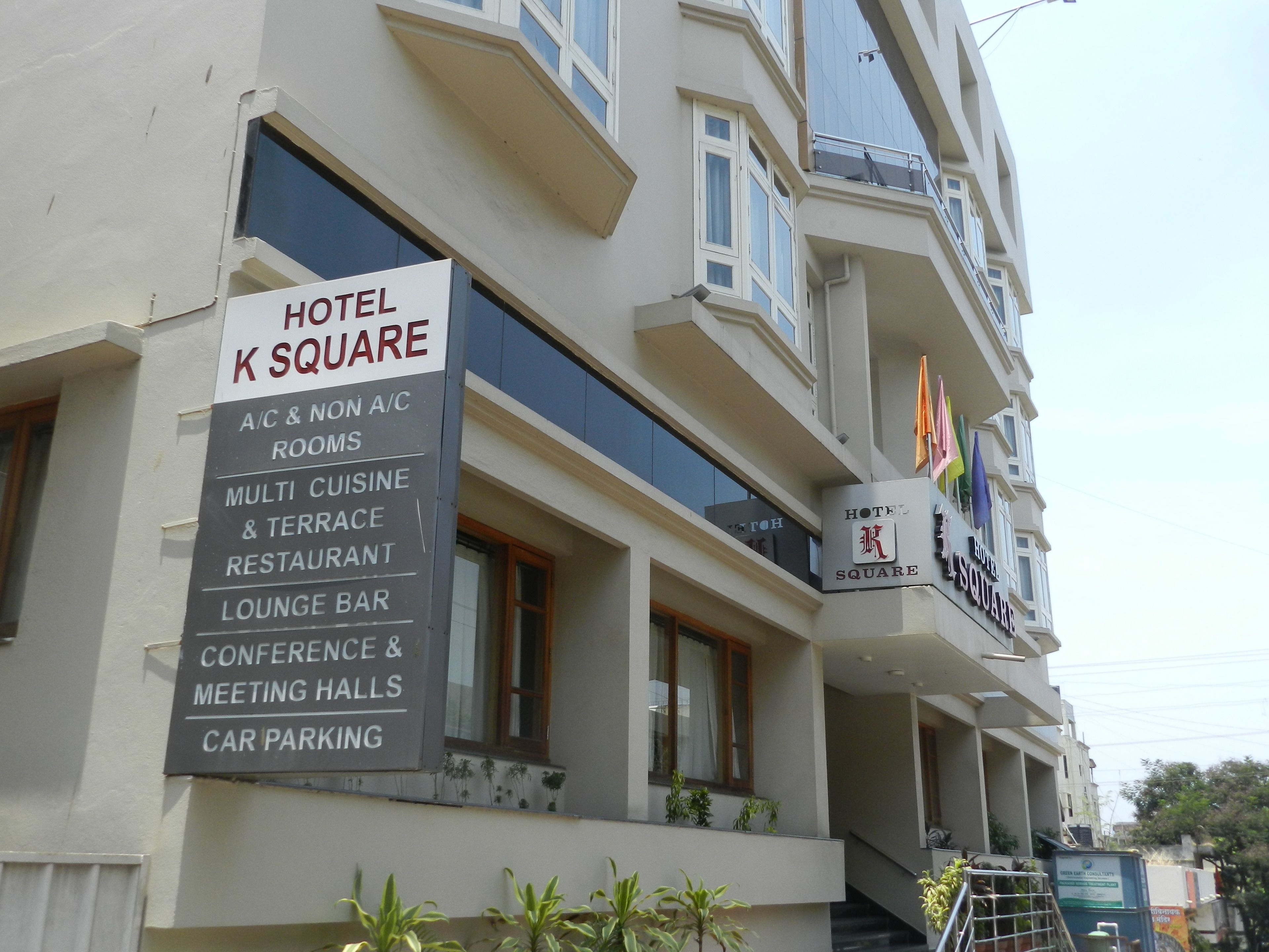 A hotel sign with amenities including A/C & non A/C rooms, multi cuisine & terrace restaurant, lounge bar, conference & meeting halls, and car parking.