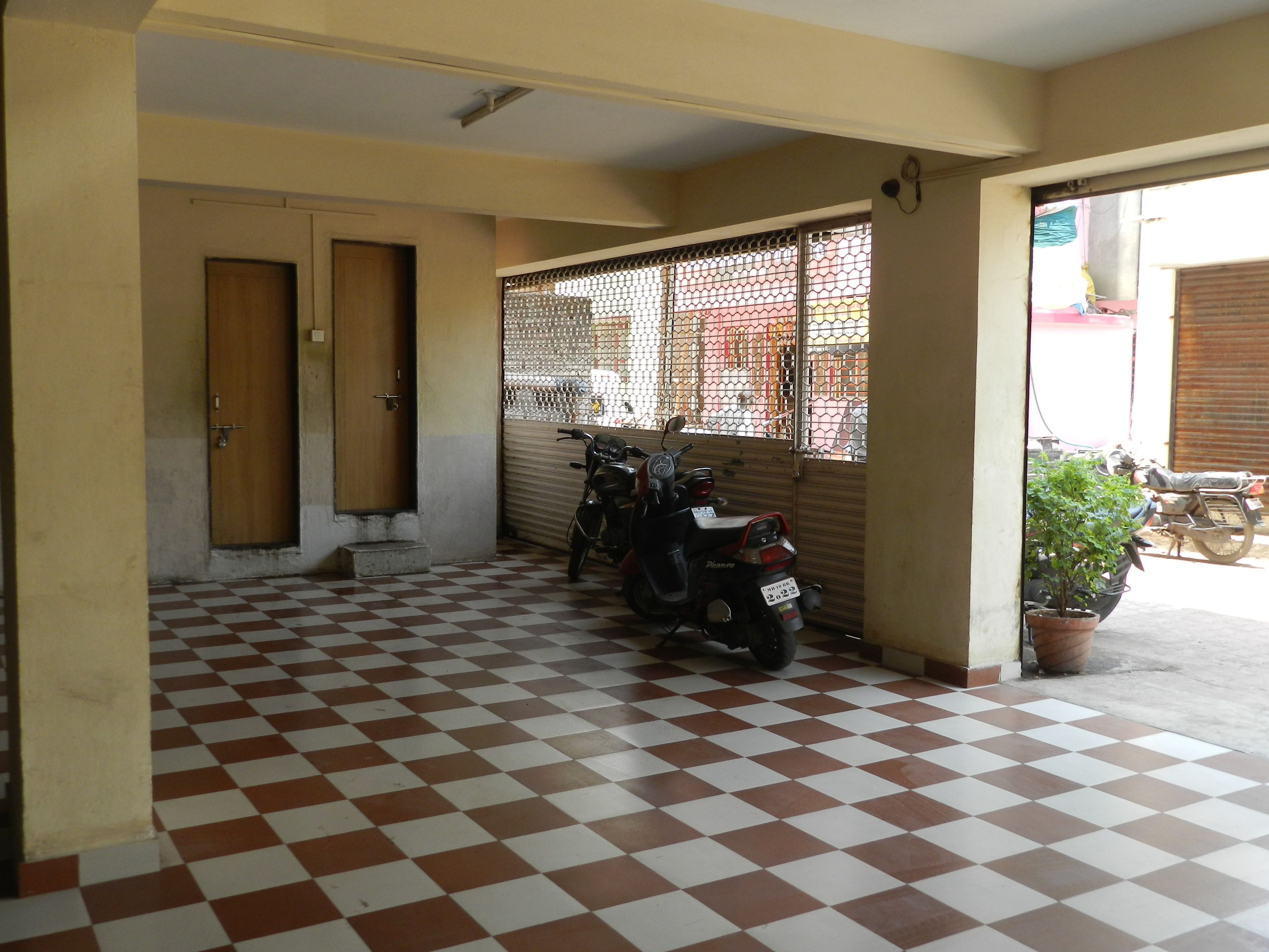 Un sol à carreaux, deux portes, une moto et une plante en pot.