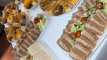 Una mesa de buffet con diferentes sándwiches y ensaladas.