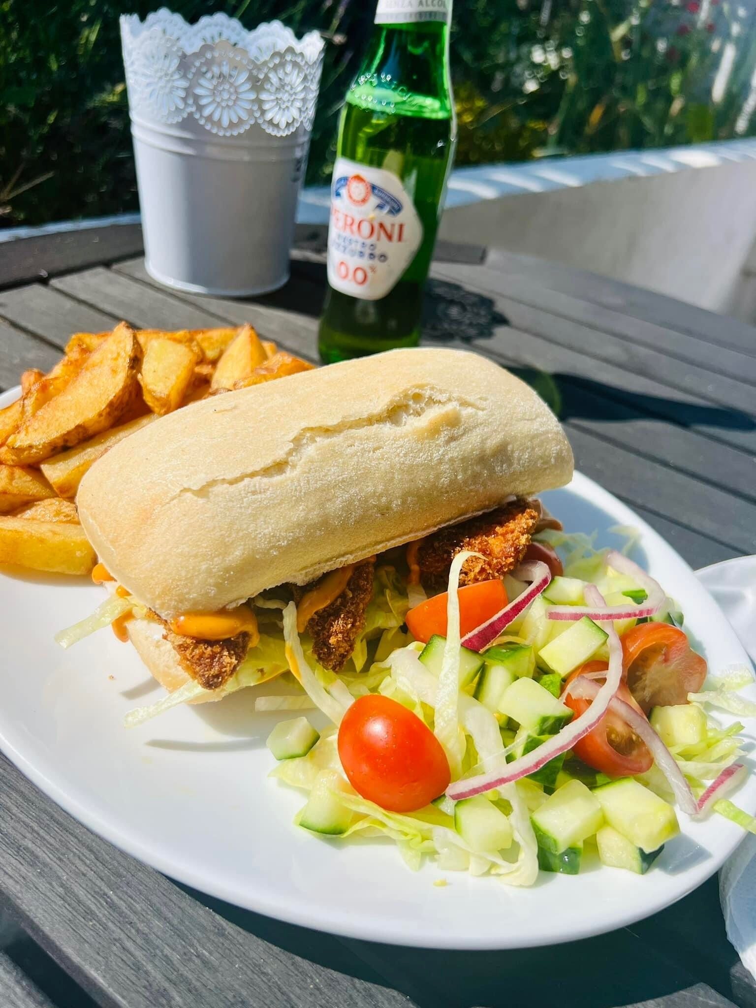 A meal consisting of a sandwich, fries, and a salad on a white plate.