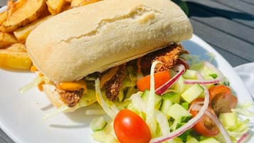 A meal consisting of a sandwich, fries, and a salad on a white plate.