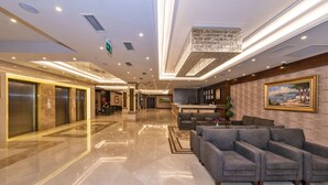 A spacious lobby with a reception desk, seating area, elevators, and a large chandelier. - Piya Sport Hotel (Istanbul)