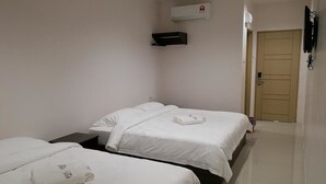 A hotel room with two single beds, a flat-screen TV mounted on the wall, an air conditioning unit, and a door. - First Guest House Cheras (Cheras)